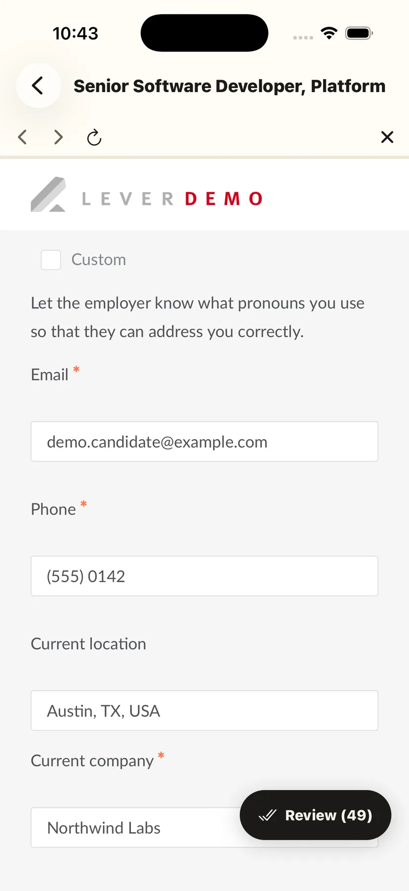 The employer's own application form after AutoStant filled it, inside the app: email, phone, current location and current company all carrying the reviewed answers, with the Review pill still offering the other forty-nine fields. Nothing has been submitted.